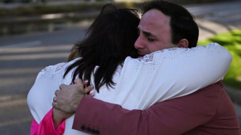 Worshippers embrace after a shooting at Lakewood Church
