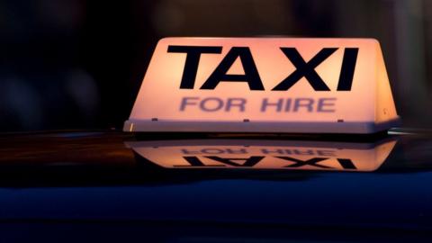 A taxi for hire light on top of a taxi