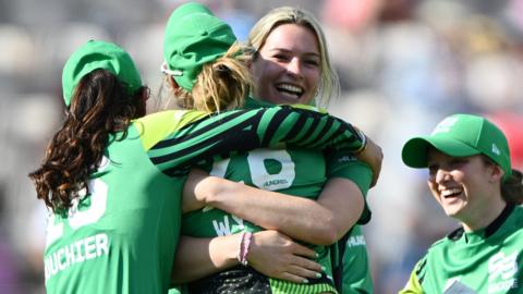 Southern Brave players embrace to celebrate a wicket