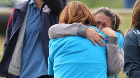 Women mourn after the discovery of the remains of children at former residential schools