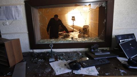 Palestinians inspect the damage inside the office of Palestine TV, in Gaza City January 4, 2019