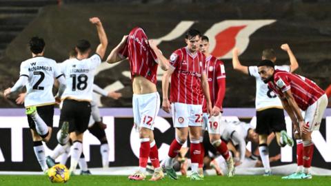 Millwall players celebrate, Bristol City players look dejected