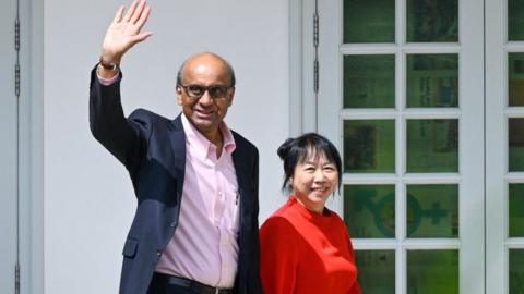 Presidential candidate Tharman Shanmugaratnam (L) and his wife Jane Ittogi waves as he arrives at the nomination centre for the presidential election in Singapore on 22 August 2023.