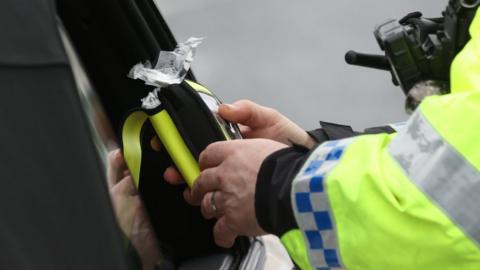 Police officer looking at a breathalyser
