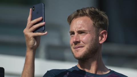England bowler Stuart Broad looks at his phone