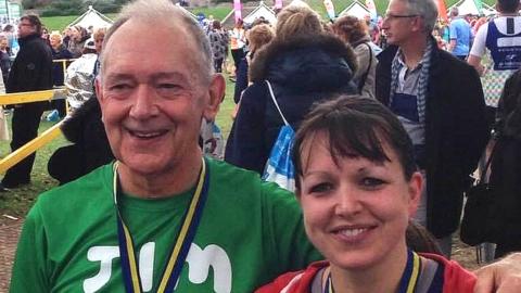 Jim Tassell smiles with a medal around his neck after participating in a race