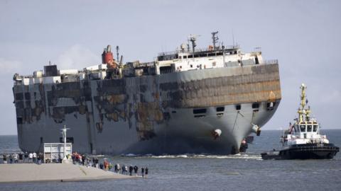 People look at the Panamanian-registered car carrier ship Fremantle Highway, from Eemshaven, on August 3, 2023
