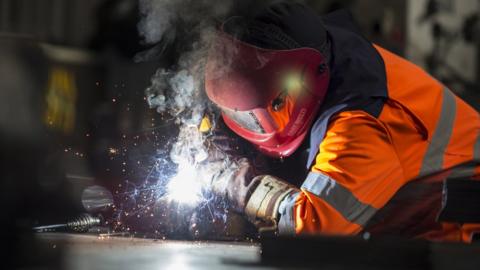 A steel worker cutting metal