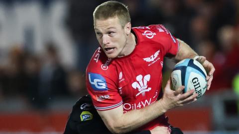 Johnny McNicholl looks to offload in a tackle for Scarlets