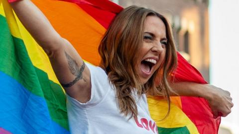 Melanie C with a rainbow pride flag on stage in 2018