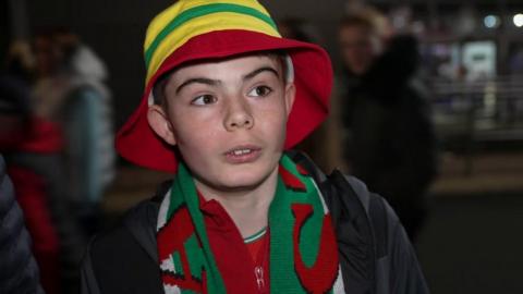 boy wearing wales team scarf and bucket hat