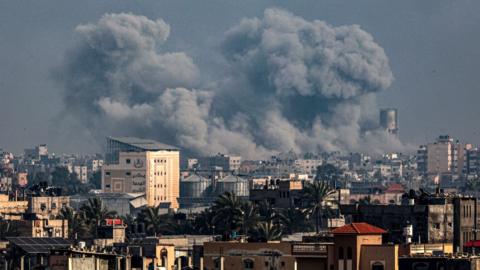 Picture taken from Rafah shows smoke billowing over Khan Yunis in the southern Gaza Strip during Israeli bombardment on 17 January 2024
