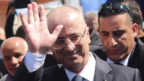 Palestinian Prime Minister Rami Hamdallah waves upon his arrival in Gaza City on 13 March 2018