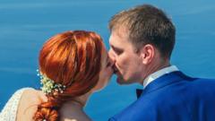 A wedding couple kissing in front of sea