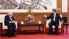 Си Цзиньпин и Генри Киссинджер сидят за столом