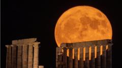 Полная луна поднимается над древним храмом Посейдона на мысе Сунион, Сунион, Греция, в понедельник.