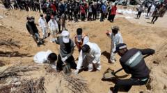 کارگران فلسطینی در حال نبش قبر اجساد در بیمارستان ناصر با بیل هستند