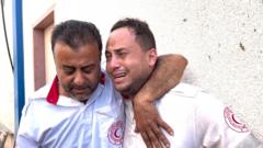 Mahmoud Al-Masry is comforted by a colleague after his father was killed, 11 October 2023