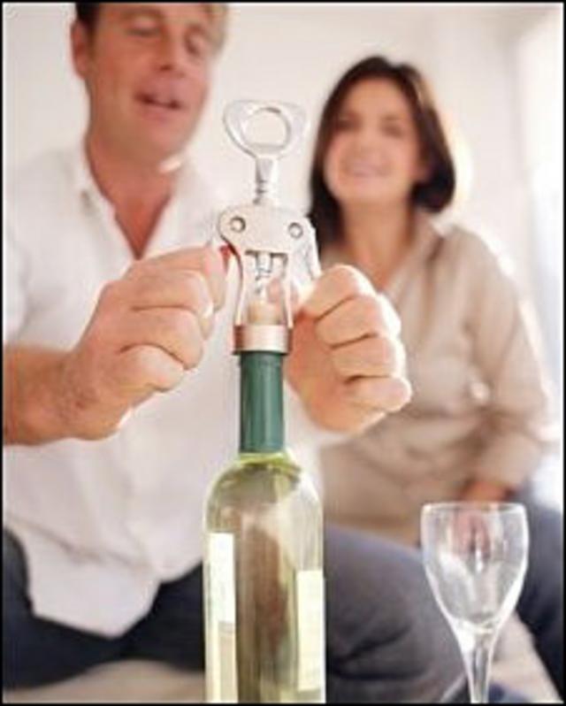 мужчина и женщина открывают бутыка вина 