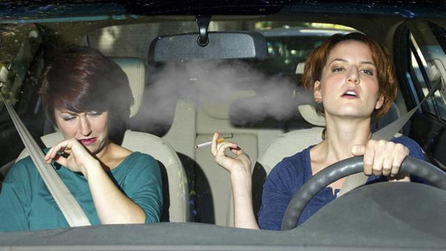 Курящая женщина за рулем