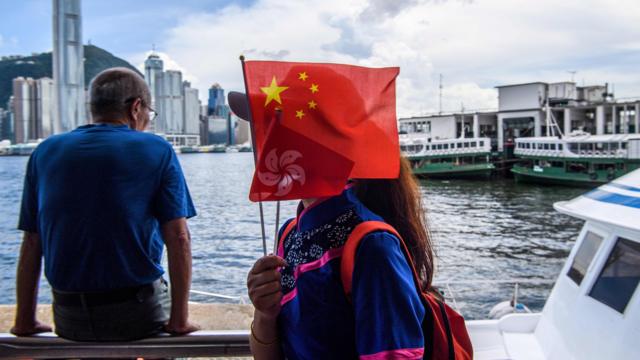 женщина в гонконге с китайским флагом в руке