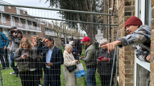 Carlos Serrano leans out of his window, offering opinions on Banksy's work