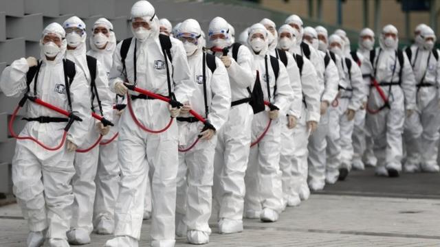 В Южной Корее солдаты, одетые в белые защитные костюмы, проводят дезинфекцию города Тэгу