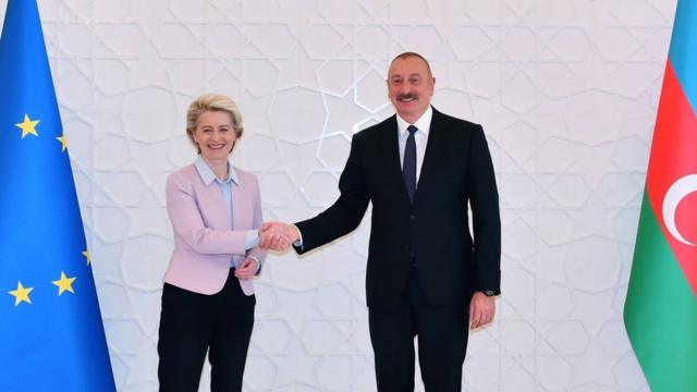 Фон дер Ляйен пожимает руку Ильхаму Алиеву на фоне флагов ЕС и Азербайджана.