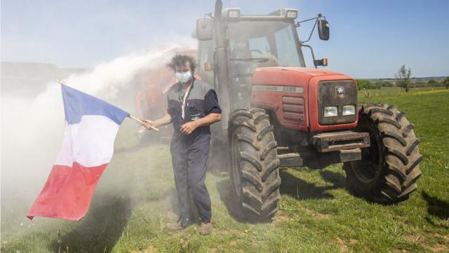 Протестующий против антикризисных мер ЕС французский фермер разбрызгивает молоко в чистом поле