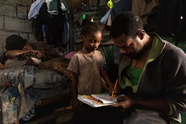 Жан-Мишель помогает с домашним заданием своей семилетней дочери