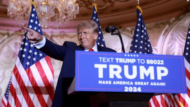 Дональд Трамп на трибуне на фоне американских флагов