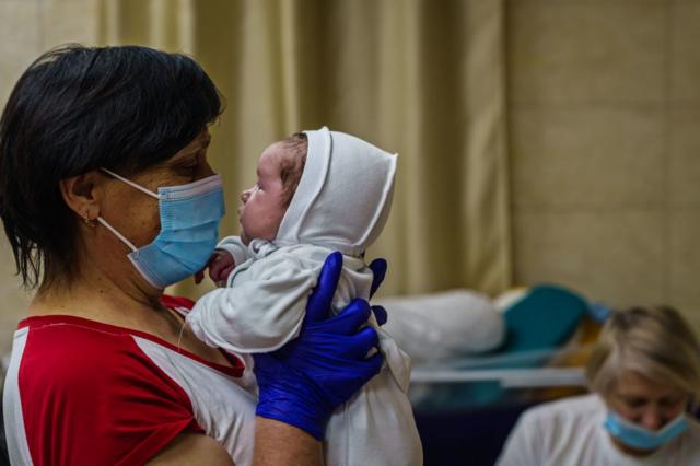 A nurse with a baby in Kyiv's underground nursery