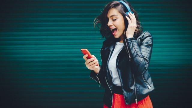 Joyful girl listening to music from smartphone