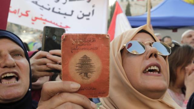 протесты в ливане, женщина в хиджабе держит паспорт