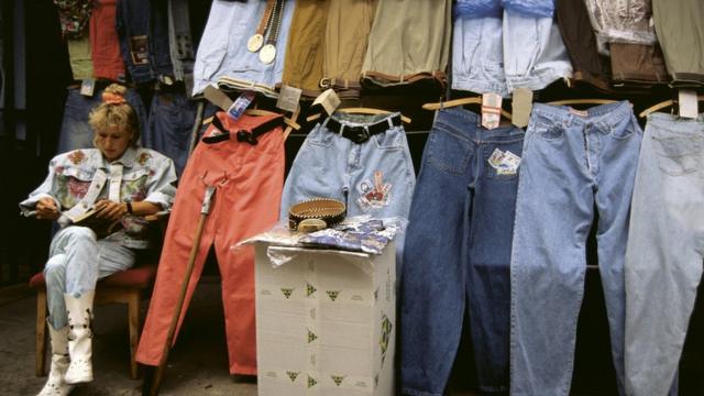 женщина продает джинсы на рынке