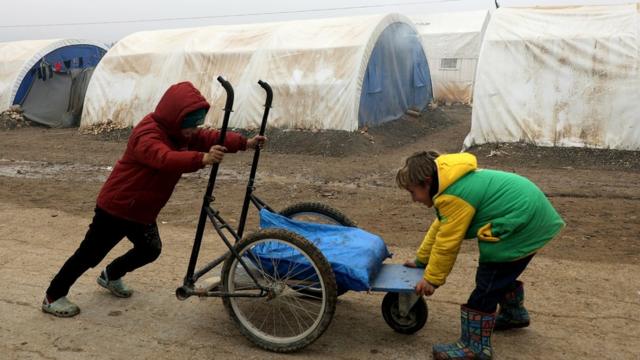 An internally displaced Syrian boy pushes a cart at a camp in the Northern Aleppo countryside, Syria December 19, 2020