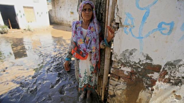 Женщина стоит возле своего дома в районе Чарсадда, провинция Хайбер-Пахтунхва, 28 августа 2022