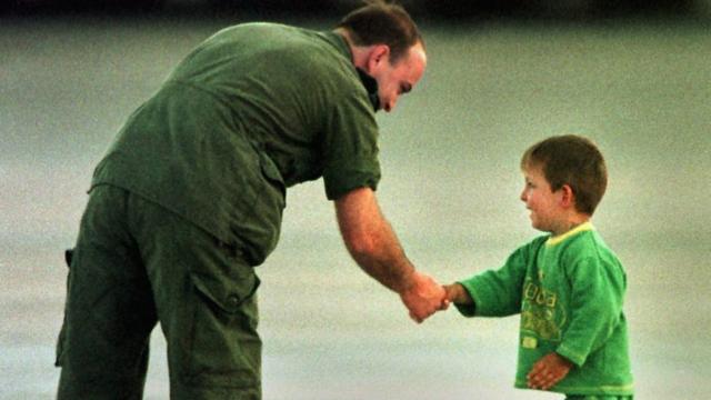 Канадский военный приветствует юного беженца из Косово в 1999 году