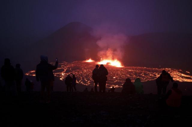 People visit the site of the newly erupted Fagradalsfjall volcano in Meradalir valley, outside the town of Grindavik - on 6 August 2022.