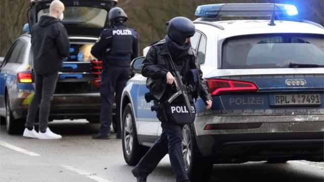 German police secure the road after the shooting of two officers in western Germany