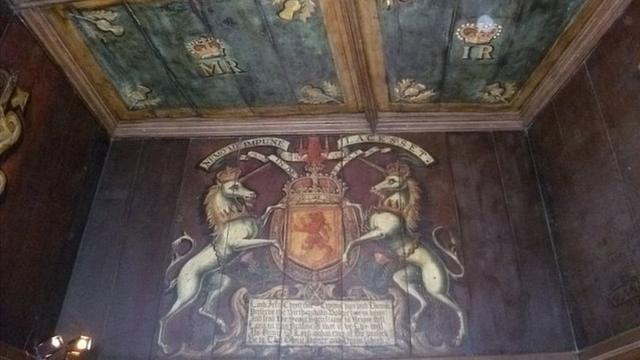 Обшитая деревянными панелями стена комнаты с гербом Шотландии