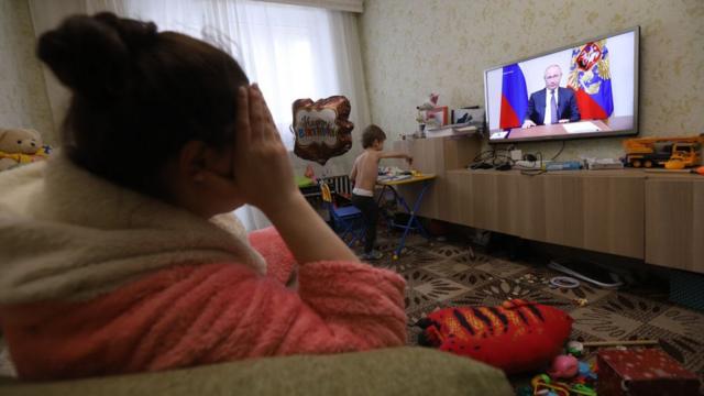 Женщина смотрит российское ТВ