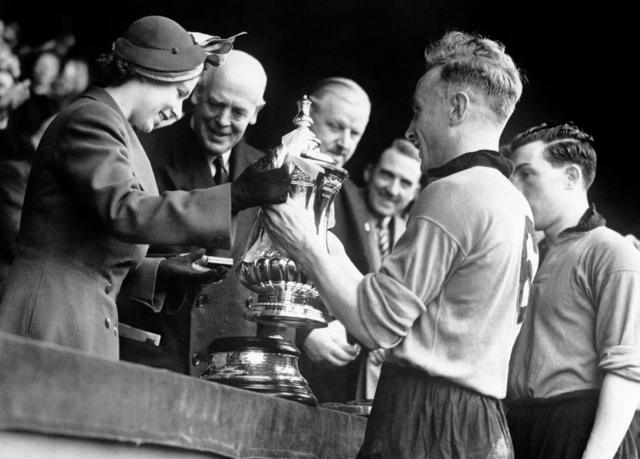 Princess Elizabeth presents the Football Association Cup to Billy Wright, captain of Wolverhampton Wanderers after Wolves defeated Leicester City by three goals to one in the final at Wembley Stadium