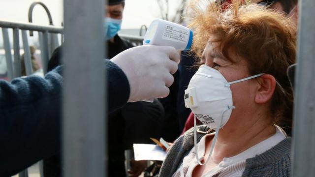 У женщины меряют температуру в Казахстане