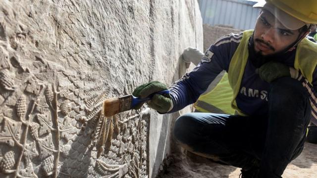 Иракский археолог очищает барельеф