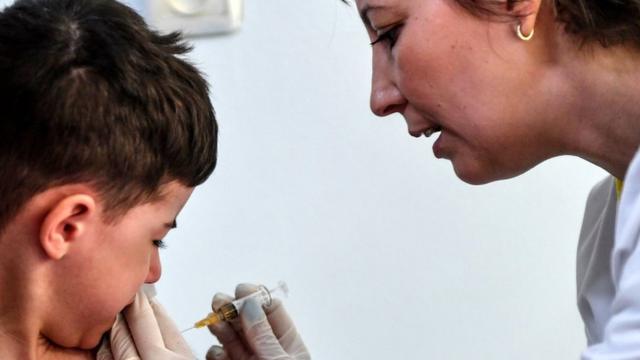 A child receives a vaccination against measles, 16 April 2018