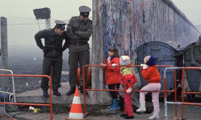 File Photo: West German School Children On The Way To School Come Across The Berlin Wall Being Opened With Two East German Border Guards During The Collapse Of Communism In East Berlin On November 14, 1989. November, 1999 Marks The 10Th Anniversary Of The Fall Of The Berlin Wall. East Germany's Communist Government Erected The Berlin Wall In August 1961. The Wall Fell After Weeks Of Massive Anti-Government Protests On November 9, 1989. The Fall Of The Berlin Wall Is Often Described As The "End Of The Cold War." East German Border Guards Shot 77 People Who Tried To Escape To The West Over The Wall During The Course Of Its Existence. (Photo By Stephen Jaffe/Getty Images)