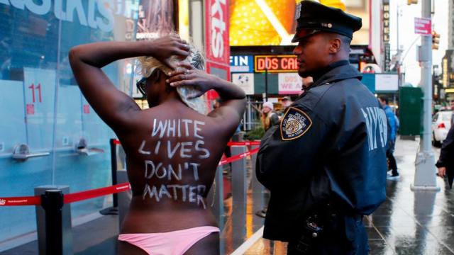Женщина с голой спиной, на которой написано: "Жизни белых не имеют значения"