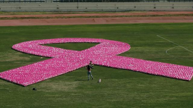 Акция на стадионе в Бейруте, октябрь 2017 года. Символ борьбы с раком груди выложили из розовых мячей на футбольном поле.