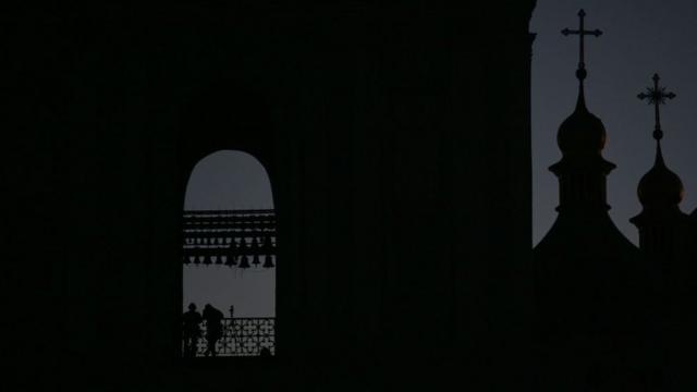 Темные силуэты церквей на фоне ночного небв